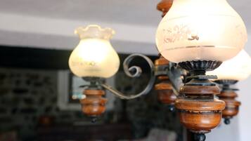 Gros plan d’un lustre orné, doté d’abat-jours en forme de bougies et de détails en bois.