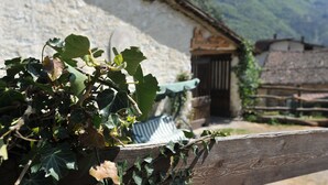 A rustic building with a stone wall and a wooden fence. - B&B Rocca di Bajedo (Pasturo)