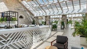 Un vaste espace intérieur comprenant un bar, des sièges et un haut plafond agrémenté de lucarnes.