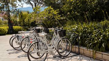 Varias bicicletas estacionadas en un área designada, con un cartel que indica servicios cercanos.