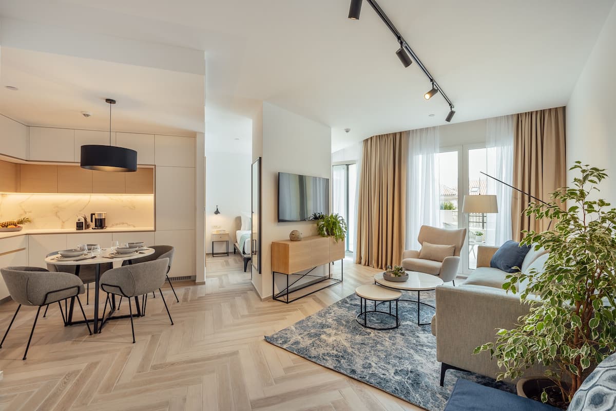 Ein modernes Wohnzimmer mit einer Couch, einem Couchtisch und einem Essbereich mit Stühlen und einem Tisch.