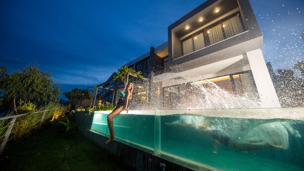 Et moderne hus med swimmingpool, have og nattehimmel.