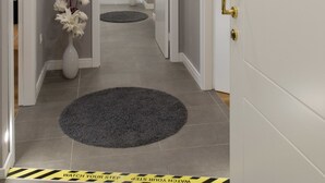 A hotel hallway with a VIP room sign, a round rug, and a caution tape on the floor.