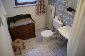 Un baño pequeño con inodoro, lavabo y mueble de madera.