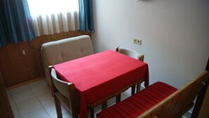 A dining area with a red table and four chairs. - Gästehaus Charlotte (Bayrischzell)