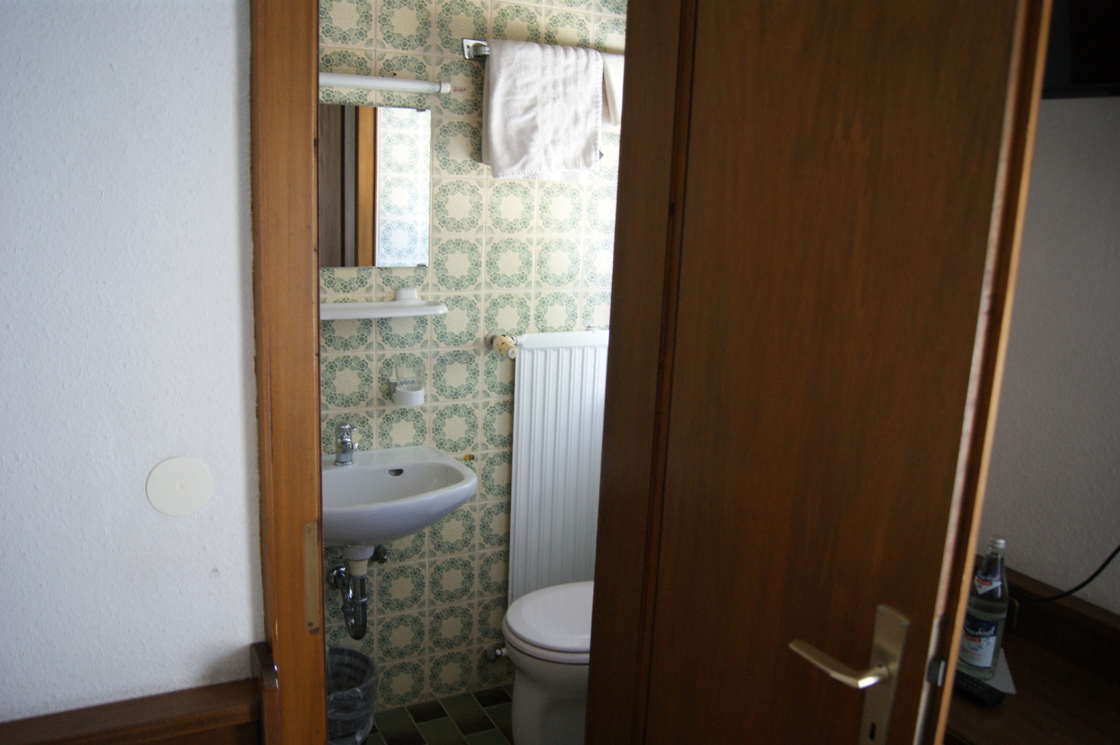 A bathroom with a white sink, a toilet, and a mirror.