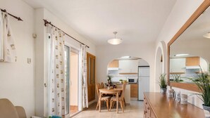 A modern apartment with a dining area, kitchen, and a cozy living space. - Apartament Arenal 1 - PlusHolidays (Calpe)
