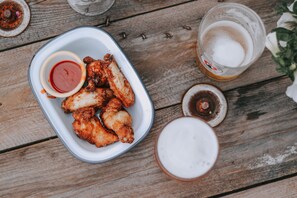 A meal of fried chicken wings with dipping sauce and a glass of beer on a wooden table. - The Town Arms (Wallingford)