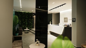 Un espace d’accueil moderne, comprenant un comptoir de réception, un mur d’accent vertical de couleur noire et un présentoir.