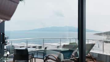 Suite Deluxe, Terraza, vista al mar | Área de sala de estar | Televisión de pantalla plana