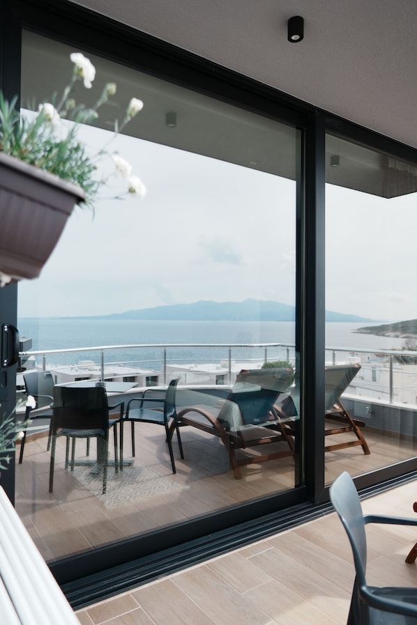 Suite Deluxe, Terraza, vista al mar | Área de sala de estar | Televisión de pantalla plana 