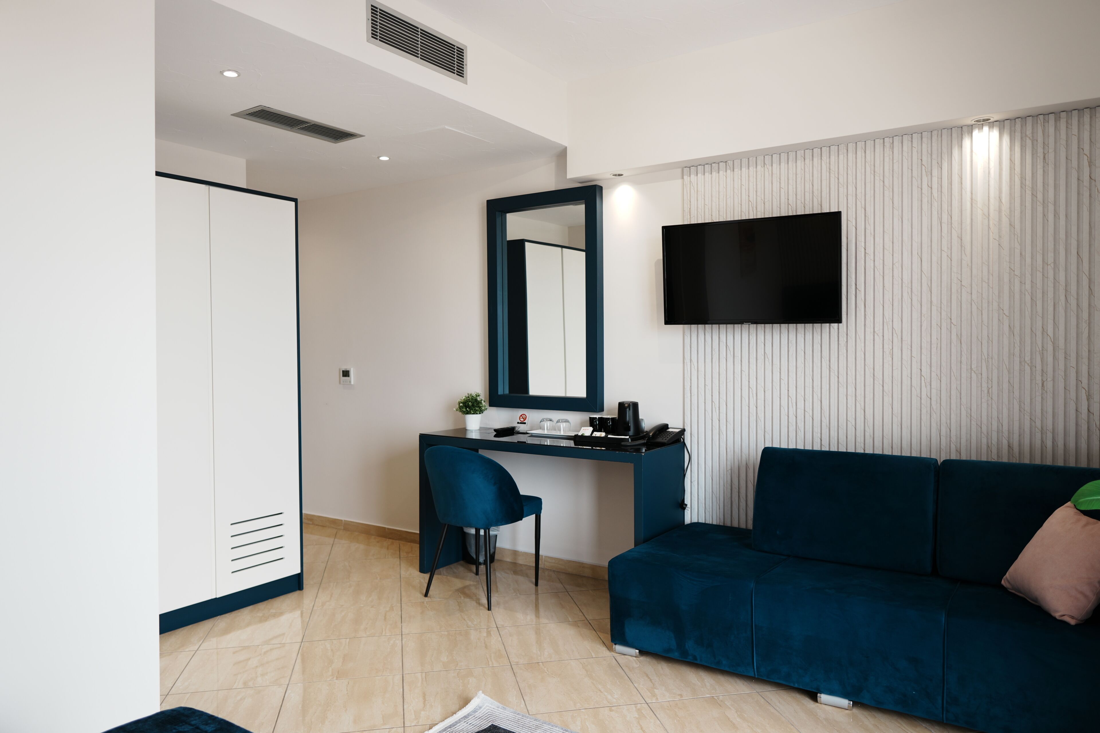 Una habitación moderna con escritorio, silla y sofá.