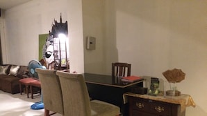 A dining area with a table, chairs, a fan, a dresser, and a decorative item on the dresser. - Moon House at Clock Tower (Chiang Rai)