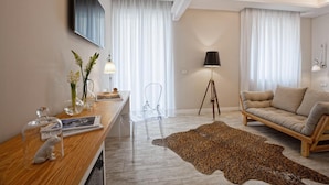 A modern living room with a wooden desk, a sofa, a leopard print rug, and a tripod lamp. - Best Season (Reggio Calabria)