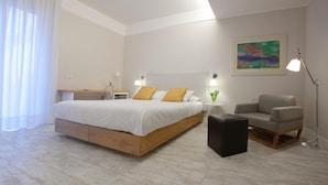 A modern bedroom with a wooden bed, a side table, a chair, and a painting on the wall. - Best Season (Reggio Calabria)