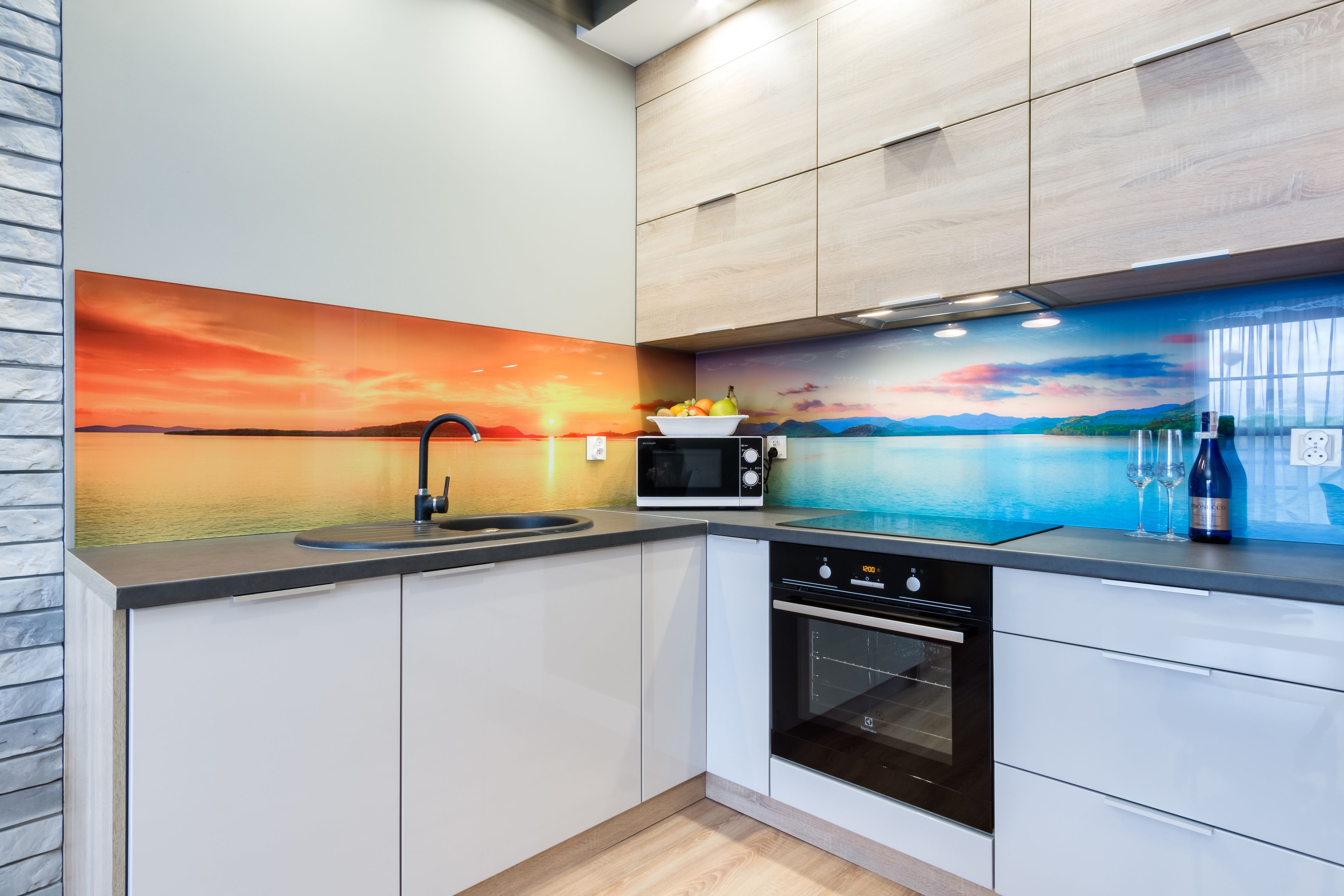 A modern kitchen with a built-in microwave, oven, and sink.