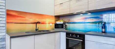 A modern kitchen with a built-in microwave, oven, and sink.