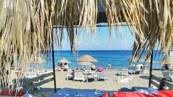 On the beach, white sand, sun loungers, beach umbrellas