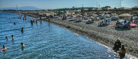 En la playa, arena blanca, sillas reclinables de playa, sombrillas