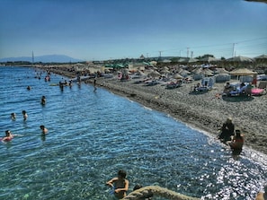 Am Strand, weißer Sandstrand, Liegestühle, Sonnenschirme