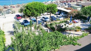 Een parkeerplaats aan de kust met auto's, een restaurant en strandparasols.
