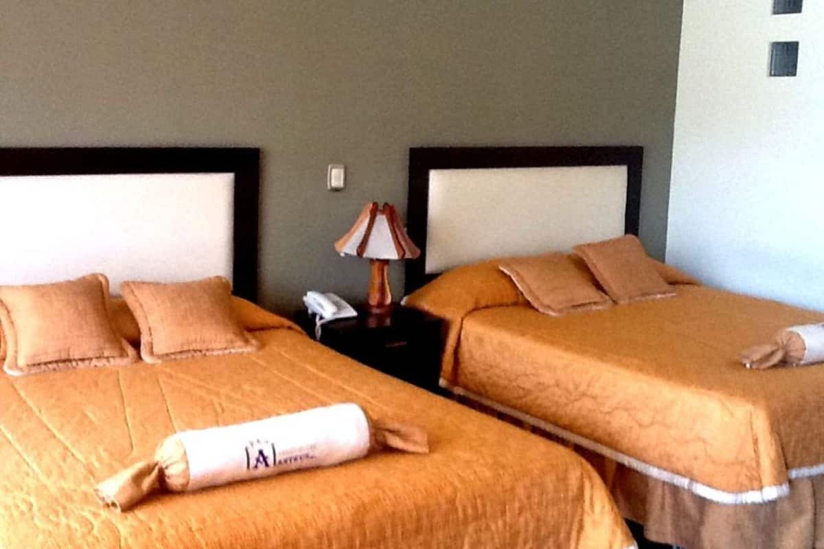 Two single beds with matching headboards, a bedside table with a lamp, and a telephone.