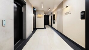 Un pasillo moderno de hotel con un cartel que indica 'Pietro 1' y un ascensor.