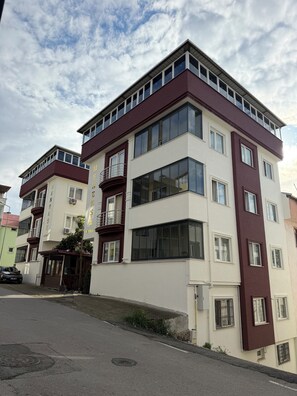 A multi-story residential building with a modern architectural design, featuring large windows and balconies. - Menekse Apart (Trabzon)