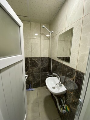 A bathroom with a shower, a sink, and a mirror. - Menekse Apart (Trabzon)