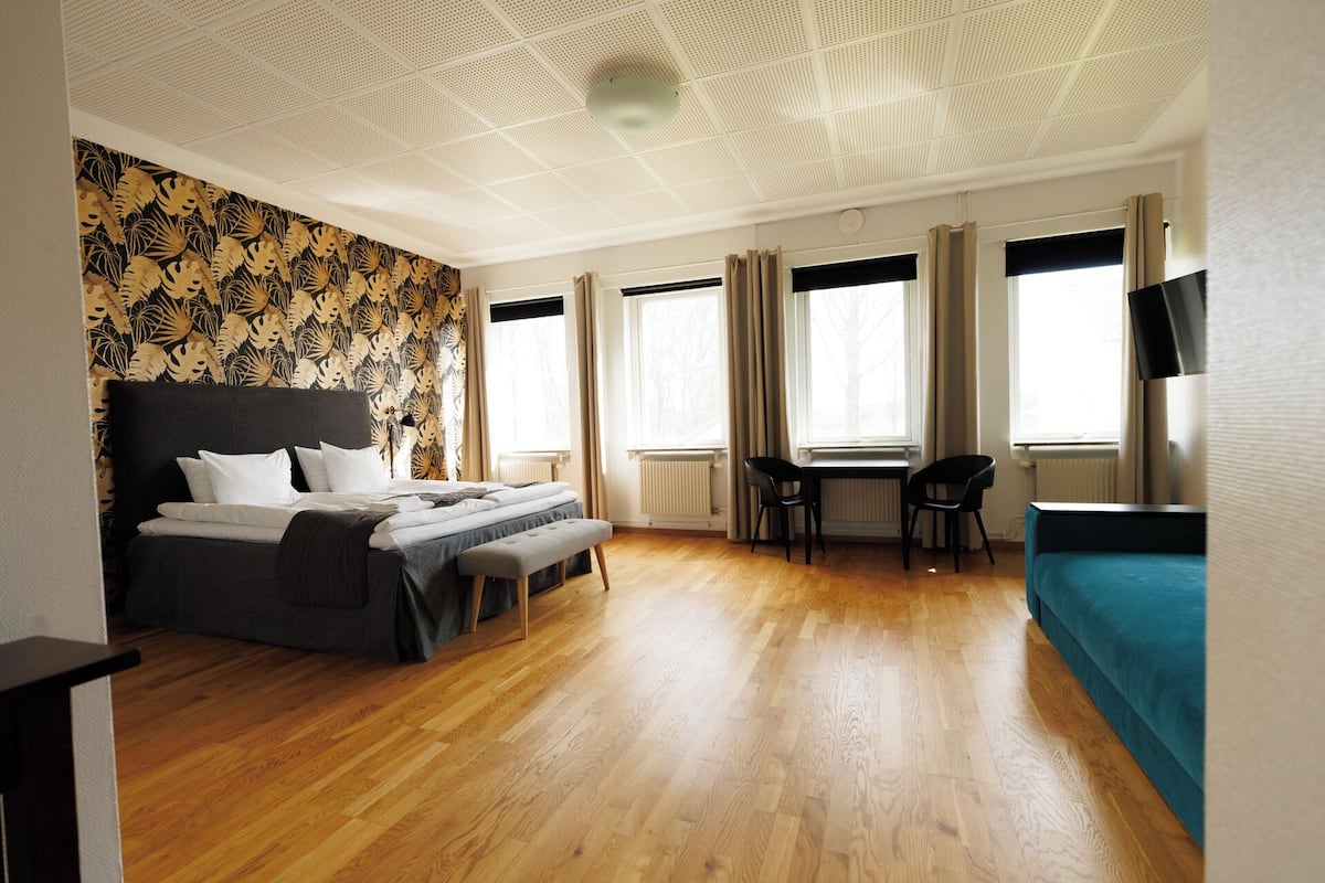 Una habitación de hotel con una cama grande, un escritorio y un sofá.