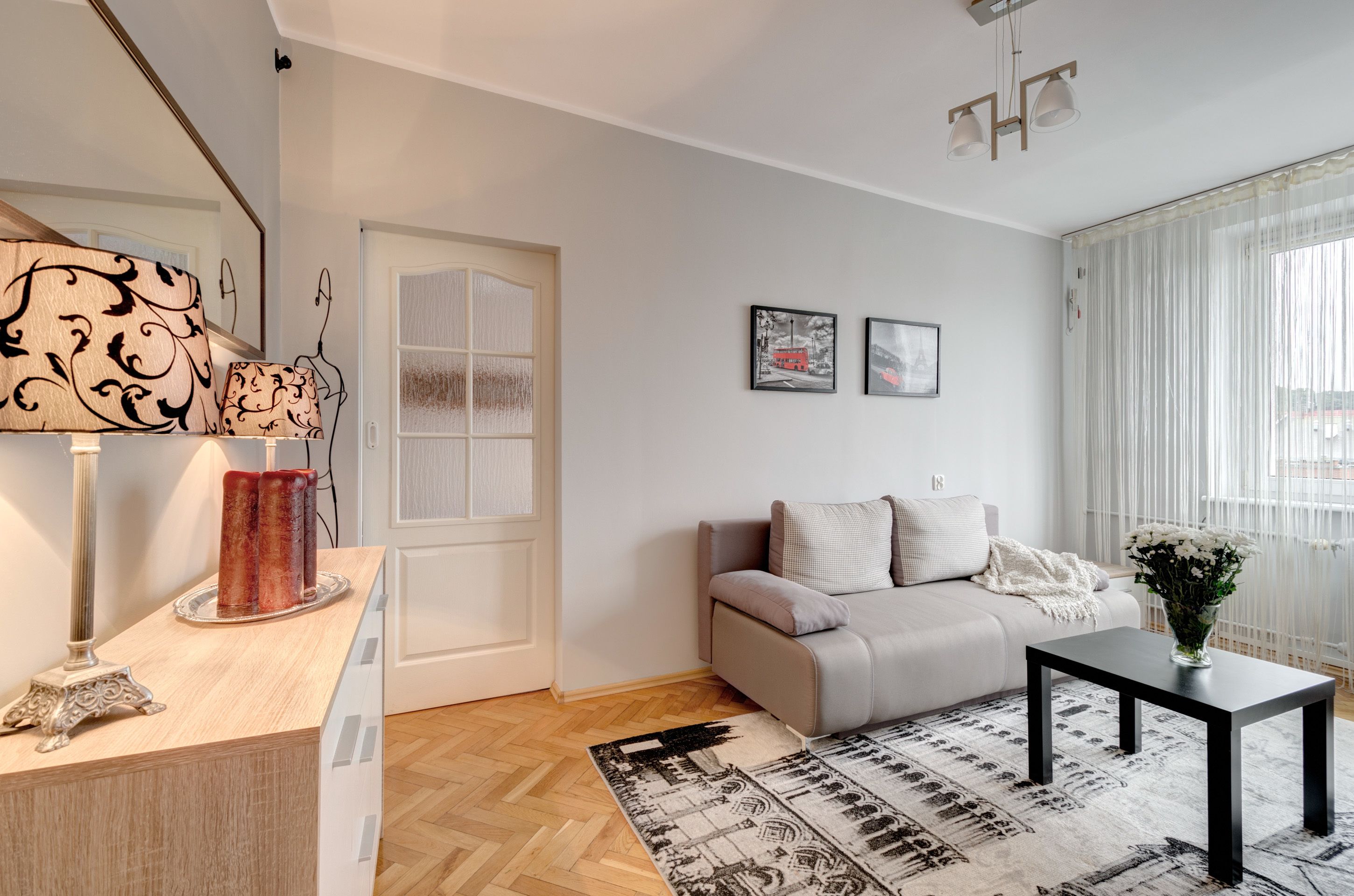 Un salon moderne avec un canapé, une table basse et une lampe décorative.