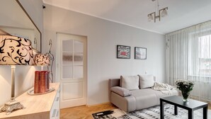 Uma sala de estar moderna com um sofá, uma mesa de centro e um abajur decorativo.