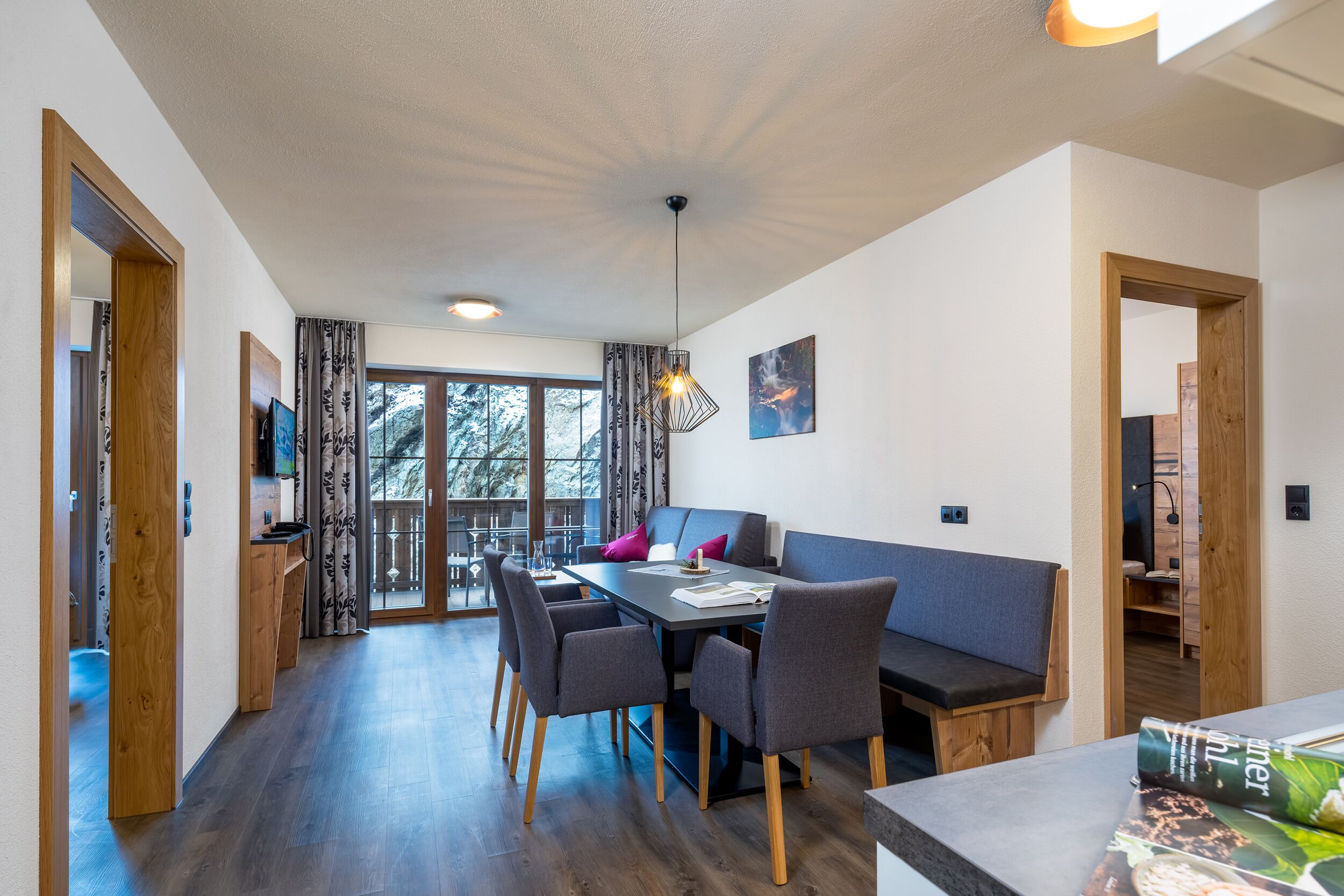 A modern dining area with a table, chairs, and a bench.