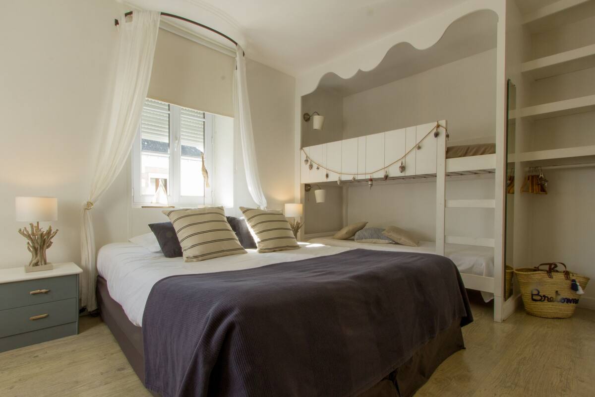 A bedroom with a bed, bedside table, and a wardrobe.