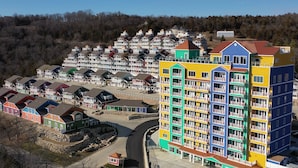 Un quartier résidentiel avec des maisons aux couleurs vives et un grand immeuble à plusieurs étages doté de balcons.