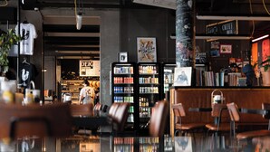 A modern interior with seating areas, a bar, and a visible store named 'DEFC'. - Exeter Hotel (Reykjavik)