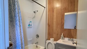 A bathroom with a bathtub, toilet, and sink.
