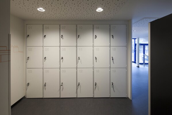 A row of numbered lockers in a hallway with a ceiling featuring small holes and recessed lighting. - easyHotel The Hague Scheveningen Beach (The Hague)