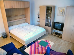 Una camera da letto con un letto, una TV, una scrivania e una sedia.
