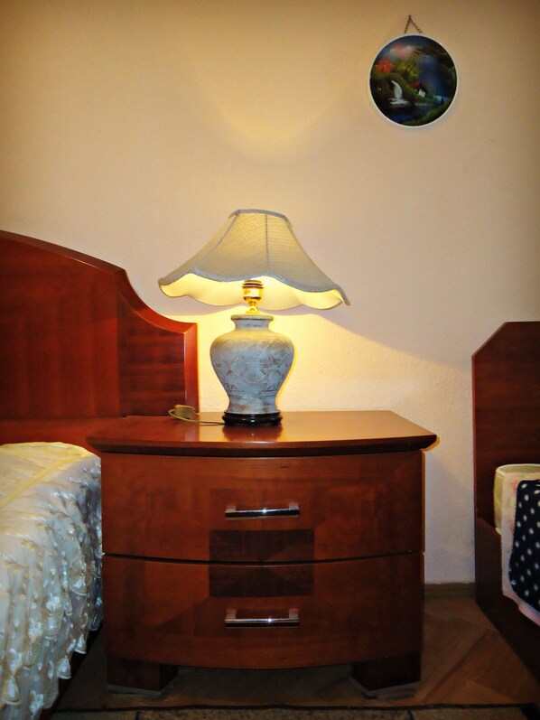 A wooden bedside table with a lamp, a drawer, and a small globe on the wall. - Albatros (Tbilisi)