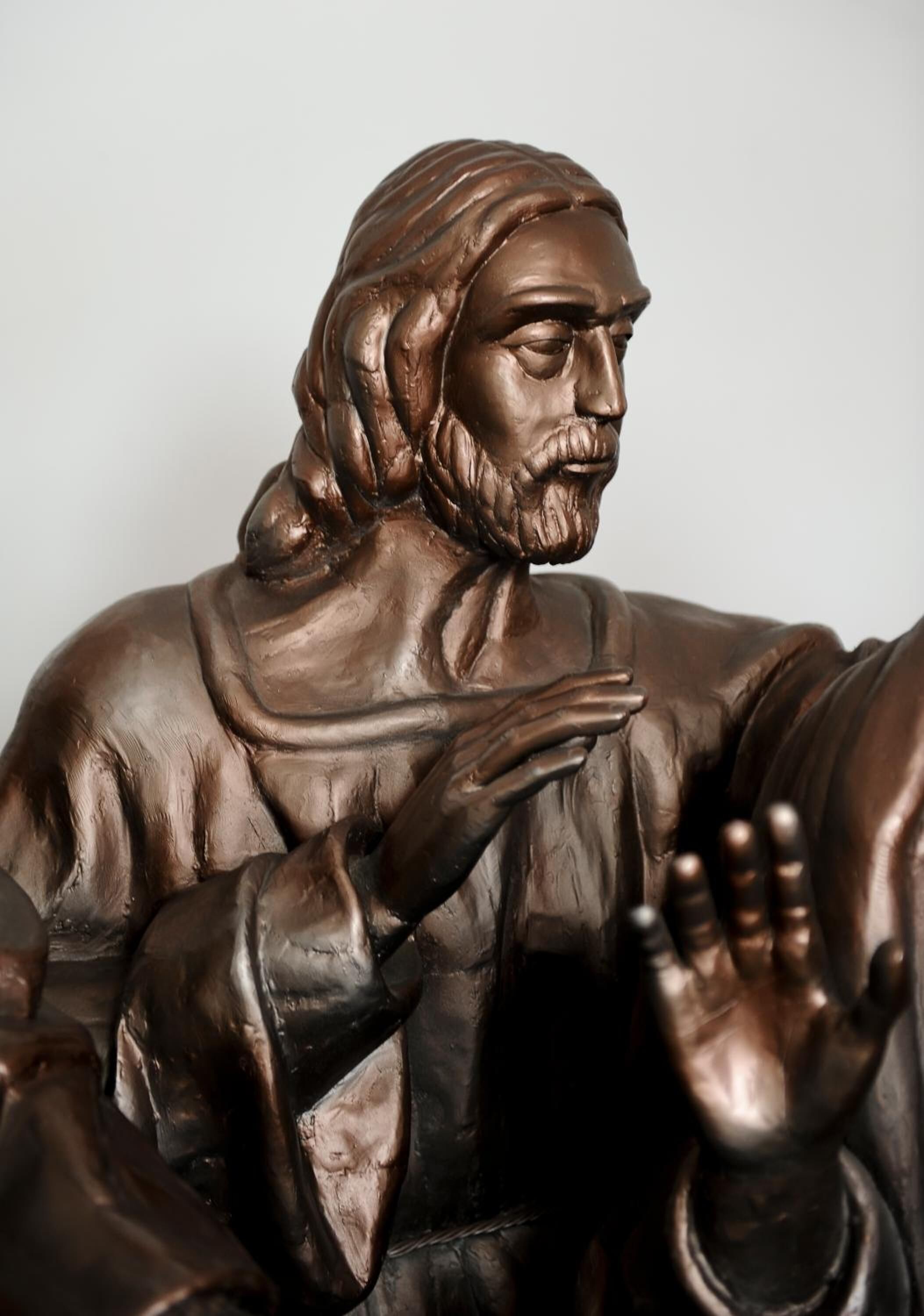 Una estatua de bronce de una persona con la mano levantada.