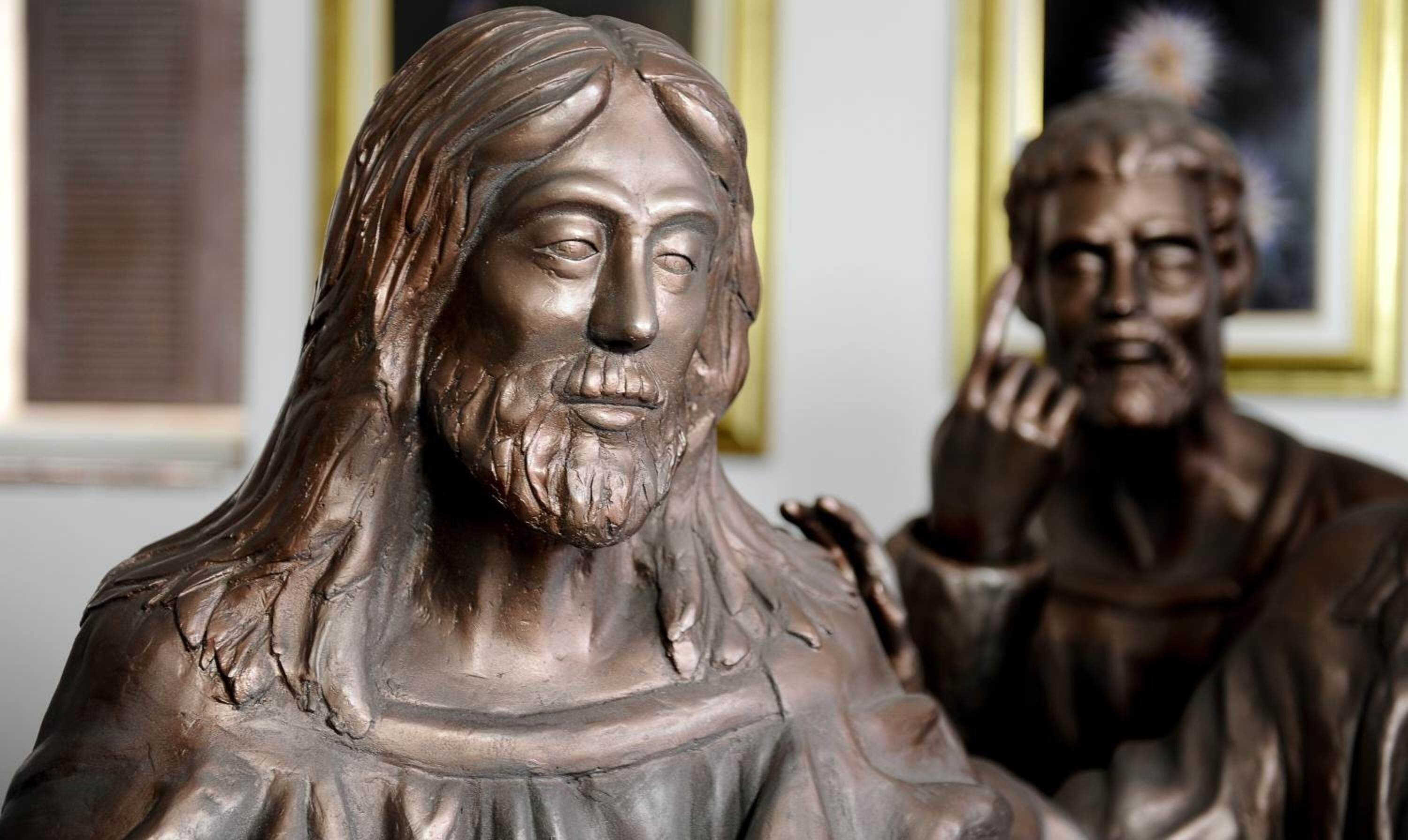 A statue of a person with long hair and a beard, wearing a robe.