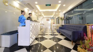 A hotel reception area with a checkered floor, a reception desk, a blue sofa, and a reception counter. - Hanoi Prime Center Hotel (Hanoi)