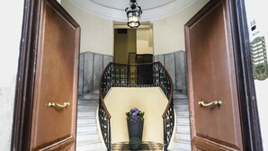 A grand entrance with a checkered floor leading to a staircase with ornate railings. - Cervia - The Hostel (Rome)