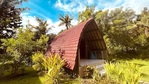 A small, red-roofed structure surrounded by lush greenery. - Apit Lawang Villas (Penida Island)