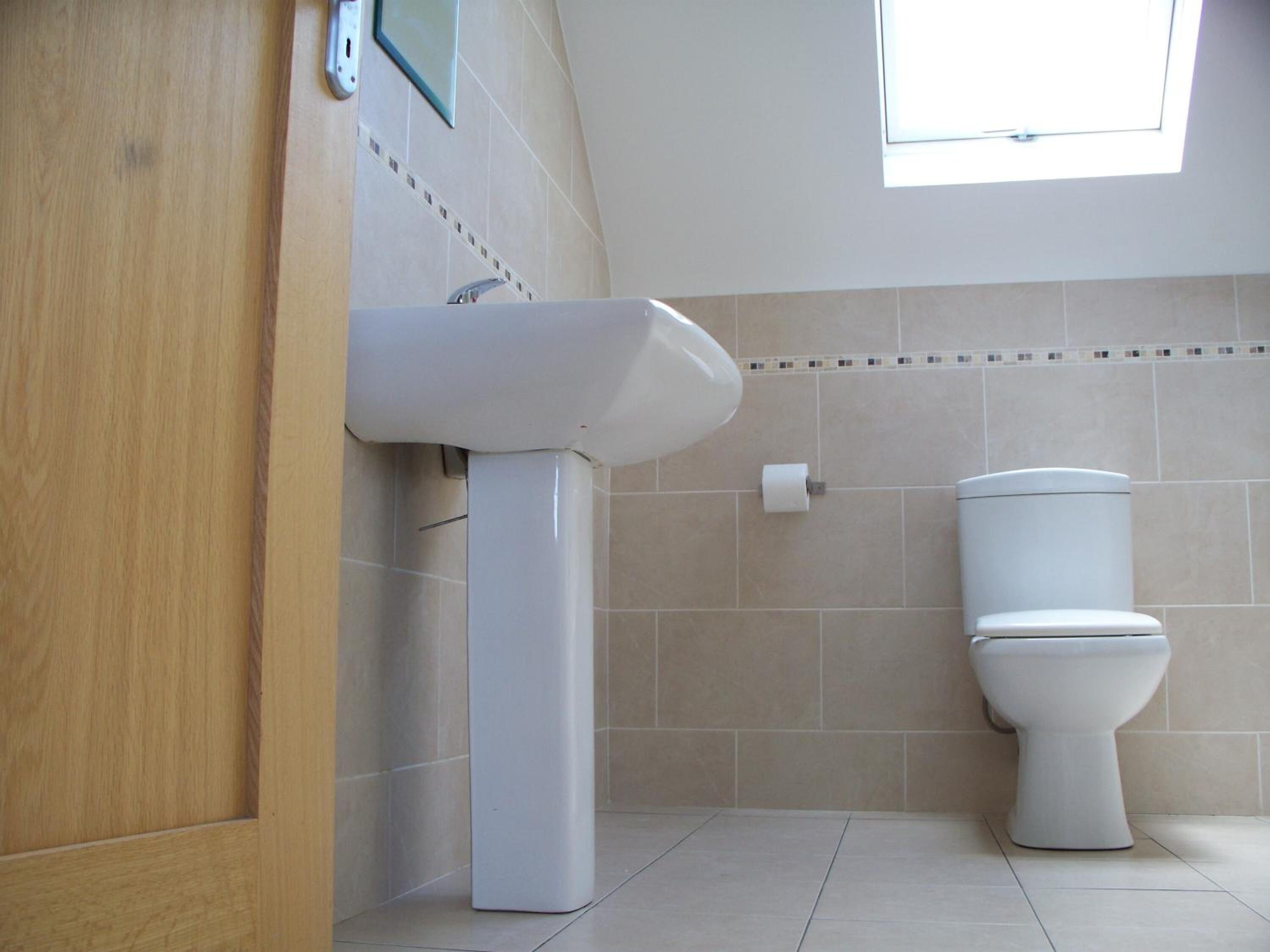 Un baño con inodoro, lavabo y ventana.