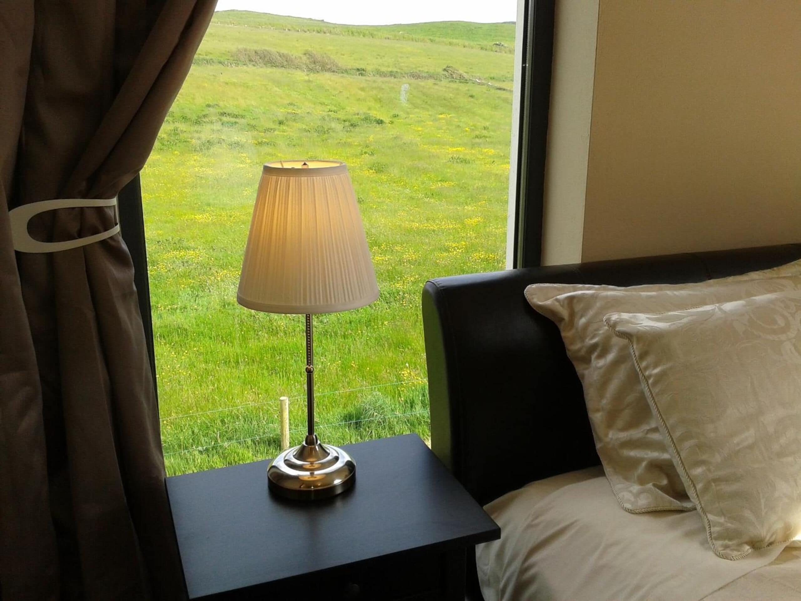 Un lit avec un oreiller blanc et une table de chevet avec une lampe.