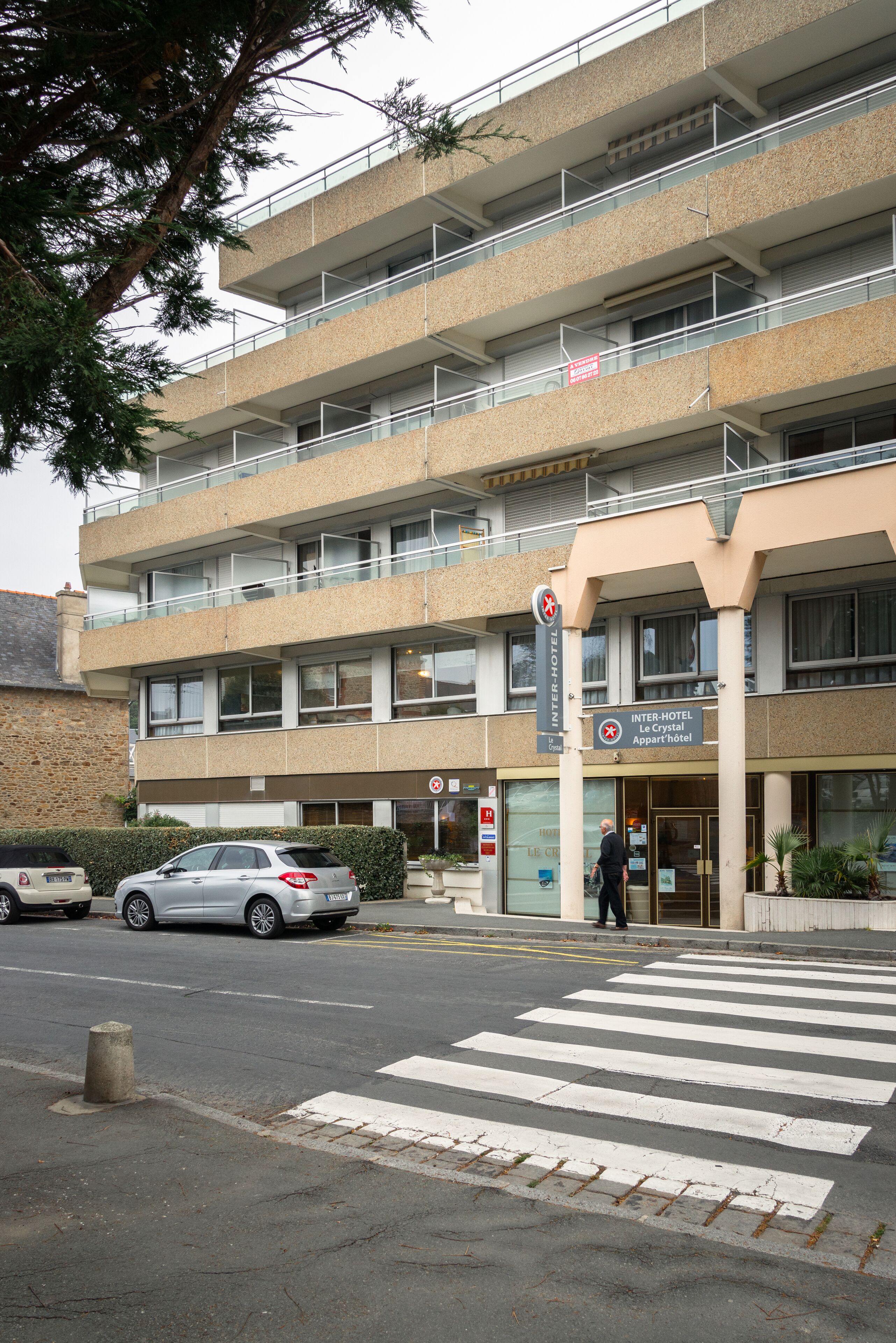 Un hôtel à plusieurs étages, doté d’une architecture moderne, de balcons et d’une entrée imposante.