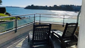A balcony with a view of a beach and the sea. - Résidence Le Crystal (Dinard)