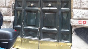A double door with a metal grille above it, set in a stone building. - Bye Bye Roma Pantheon Suite (Rome)